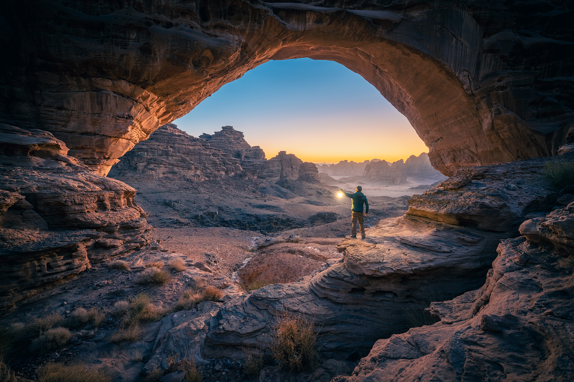 A man is standing inside a cave at NEOM mountains