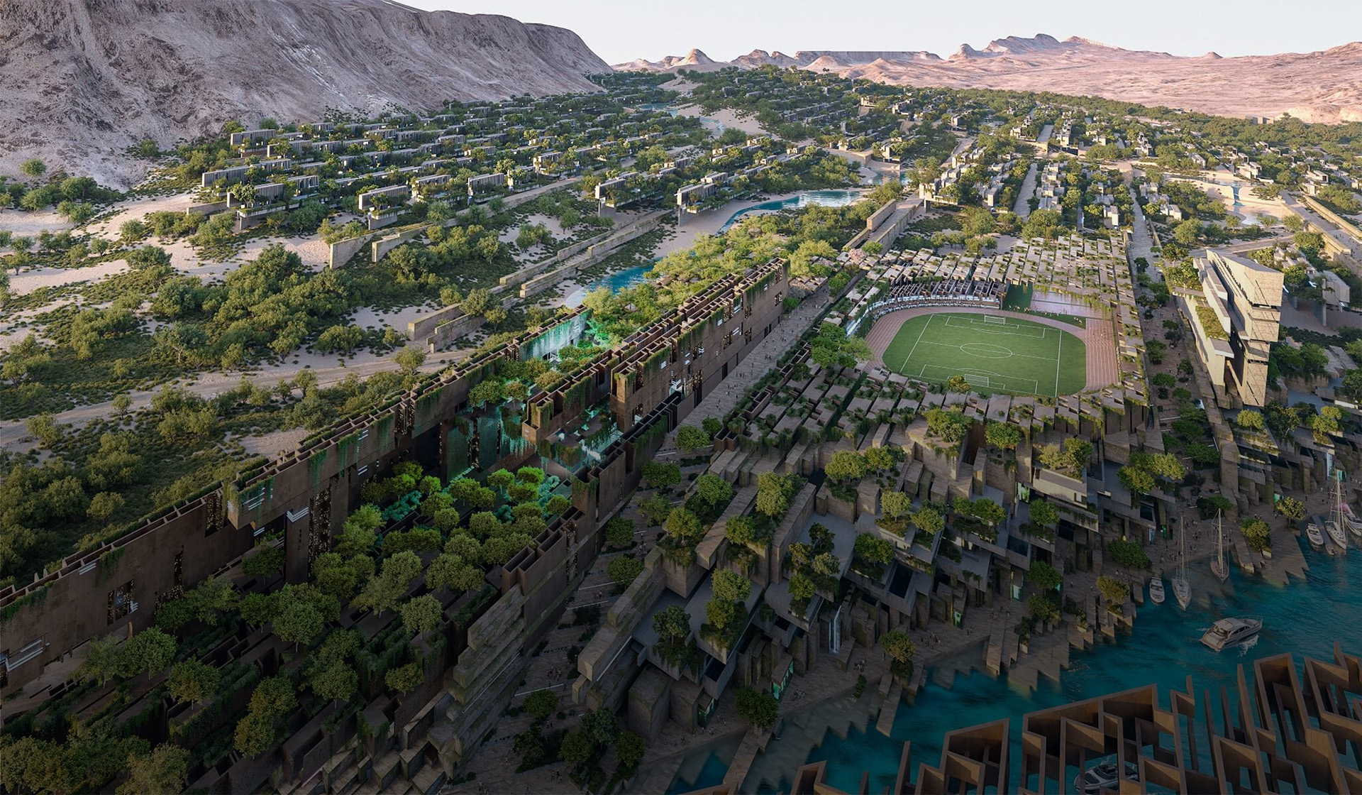 Vue aérienne de la communauté de Jaumur nichée dans les montagnes, avec un grand stade de soccer au centre  